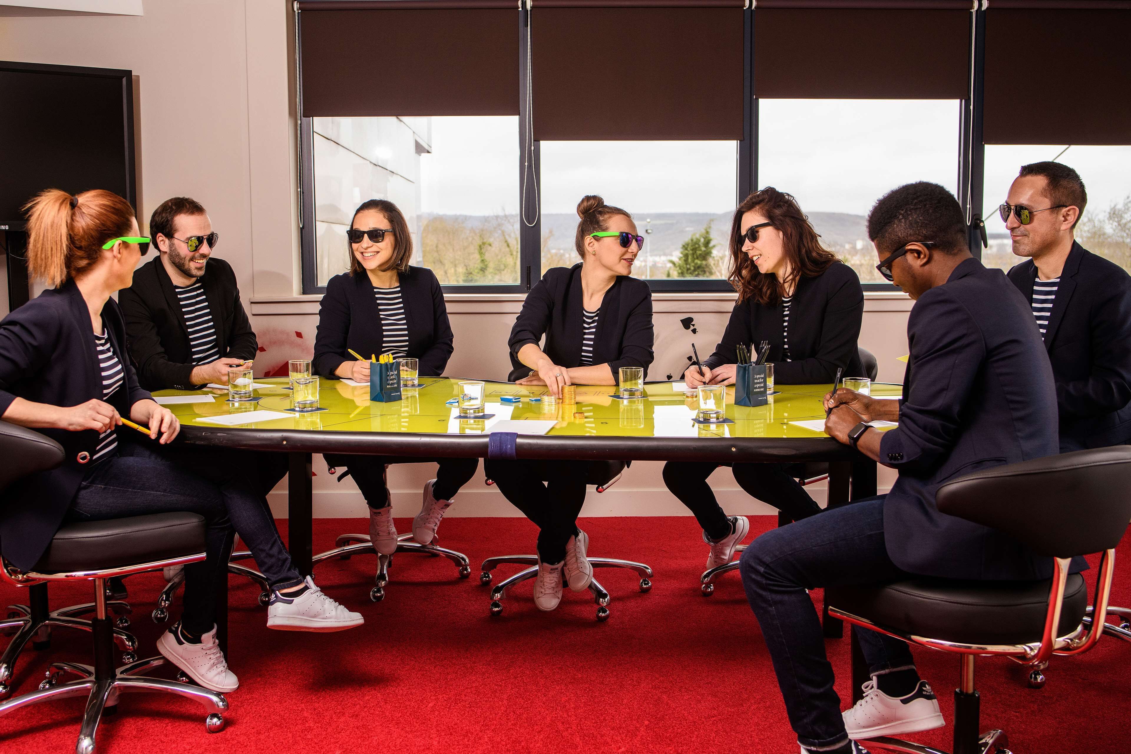A conference room with a long table, chairs, and a red carpet.