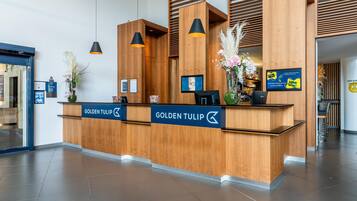 A reception desk with a wooden finish, a Dell monitor, and a sign reading 'Golden Tulip Casino.'