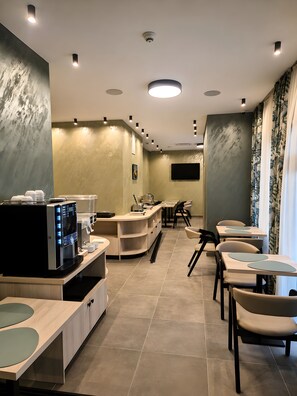 Un restaurante moderno con mostrador, sillas y un televisor de pantalla plana en la pared.