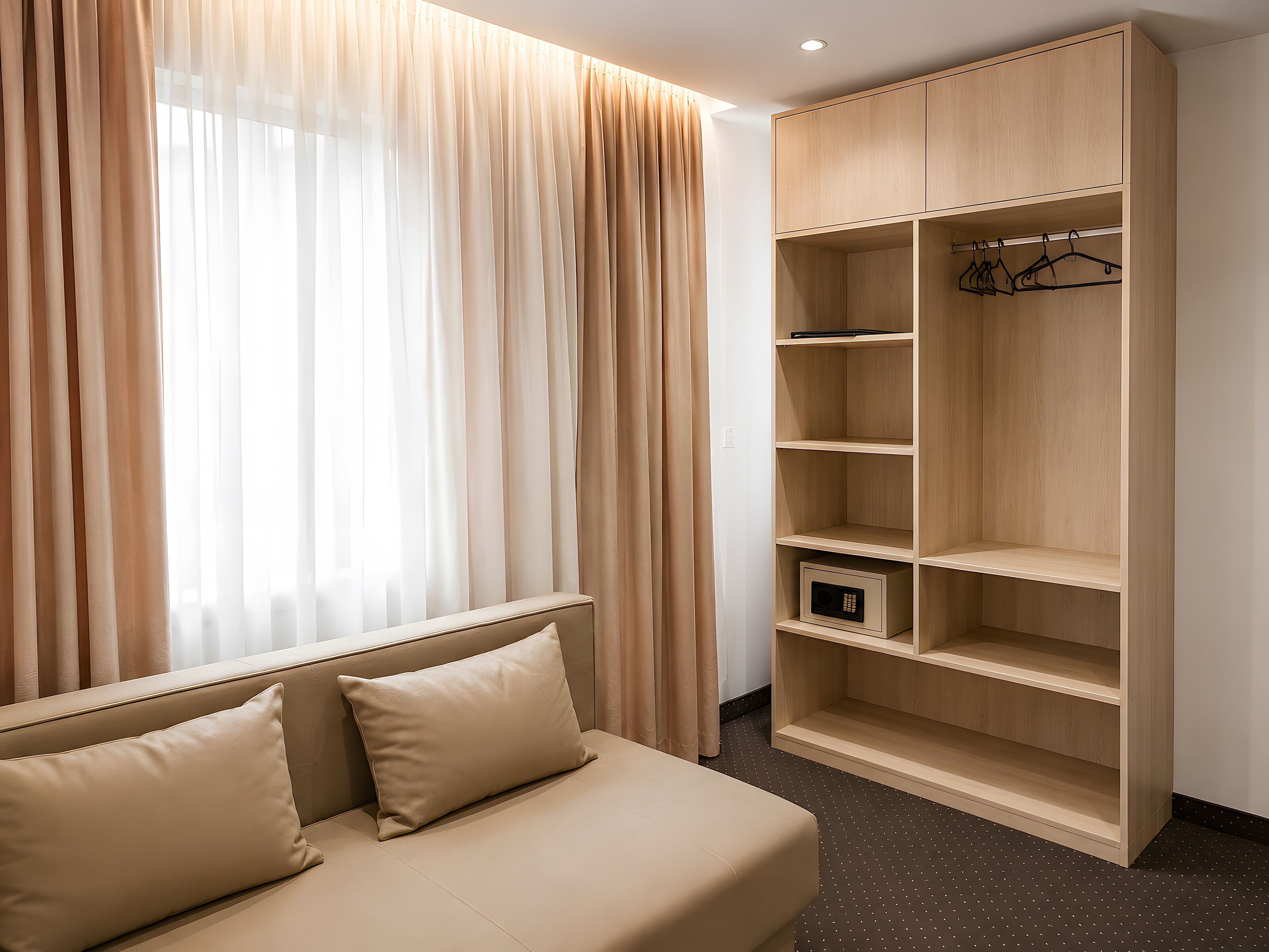 Una habitación con cama, armario y ventana con cortinas.