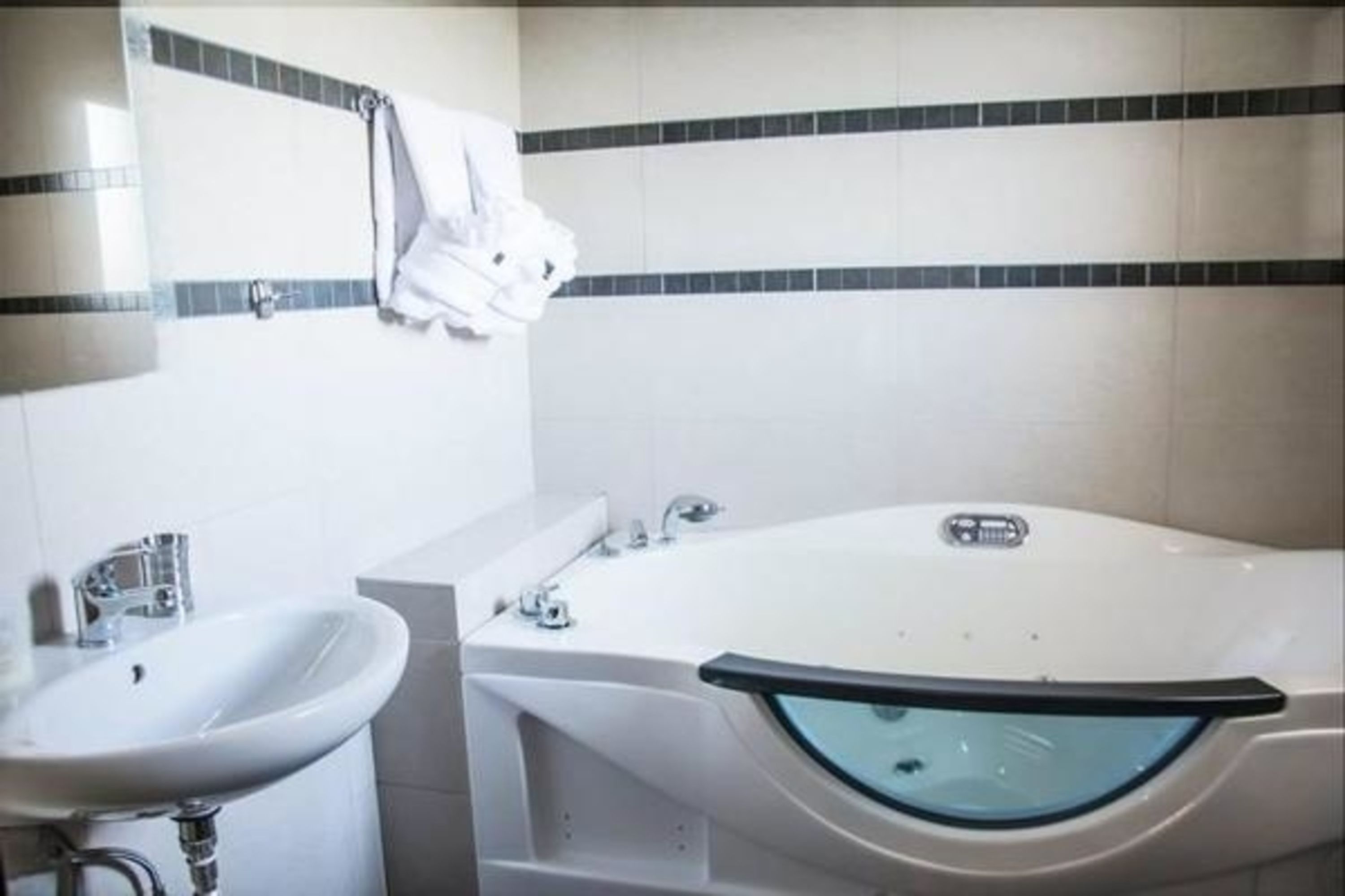 A bathroom with a sink, a mirror, and a bathtub.