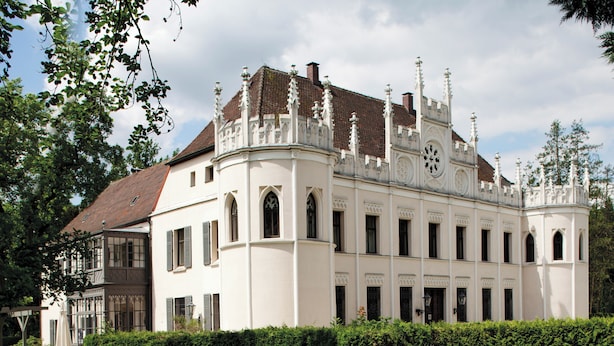 A large, historic building with a symmetrical facade, multiple windows, and ornate architectural details.