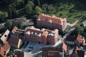 Stunning historic complex with a central building and surrounding structures, set amidst lush greenery.