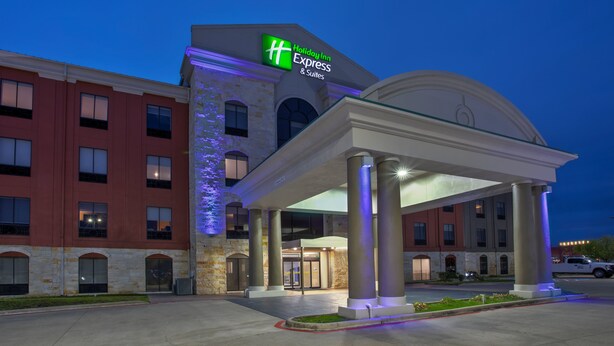 A Holiday Inn Express & Suites hotel with a modern facade, large columns, and a well-lit entrance. - Holiday Inn Express & Suites Houston West - Katy by IHG (Katy)