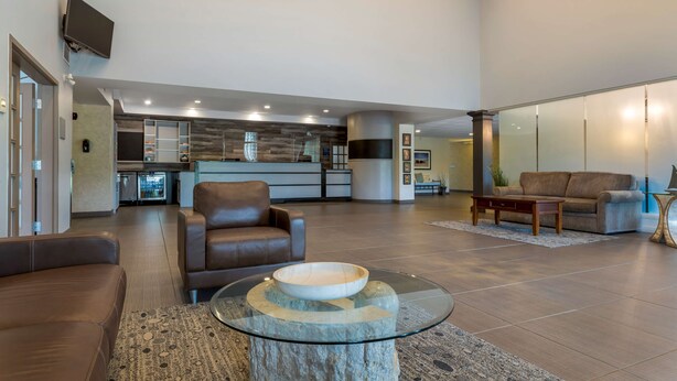 A spacious living area with a modern kitchen in the background, leather sofas, and a glass coffee table. - Best Western Plus Liverpool Hotel & Conference Centre (Brooklyn)