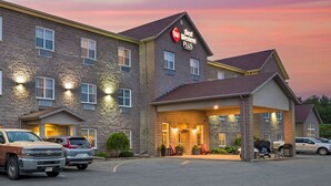 A Best Western Plus hotel with a brick facade, multiple windows, and a covered entrance area with outdoor seating. - Best Western Plus Liverpool Hotel & Conference Centre (Brooklyn)