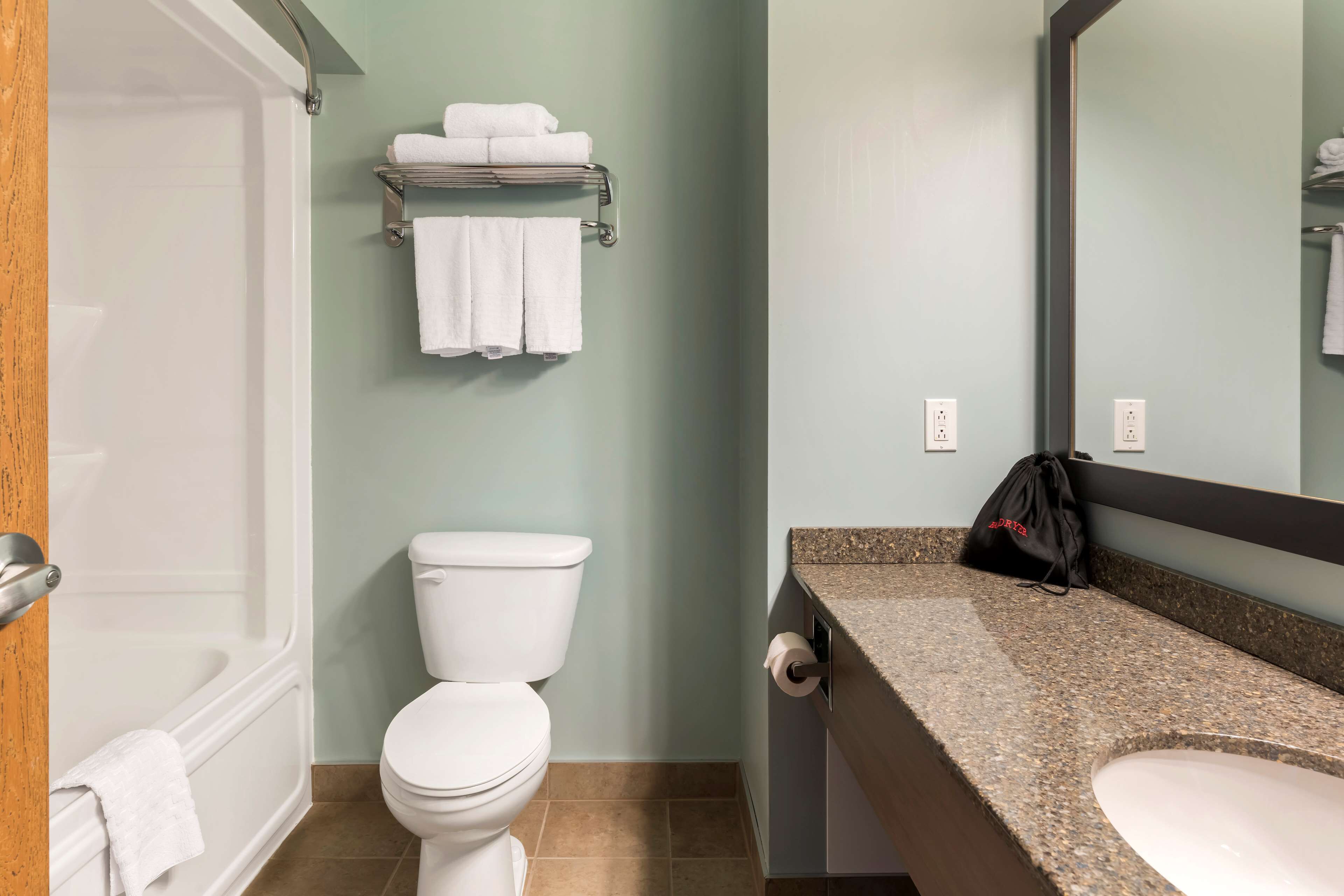 Un baño con bañera, inodoro y lavamanos.