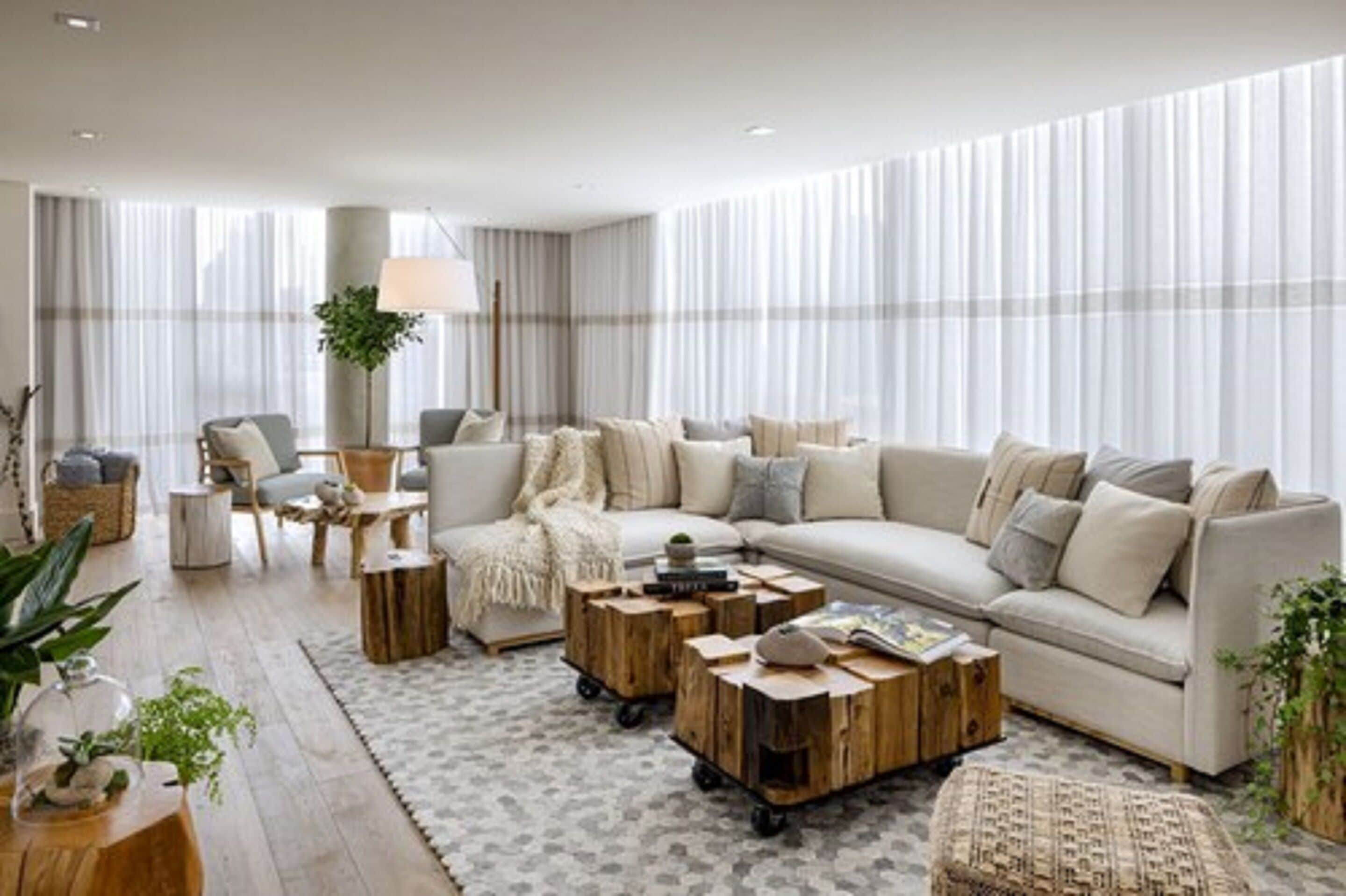 A modern living room with a large sofa, wooden coffee tables, and a floor lamp.