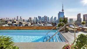 A rooftop pool with a city skyline view, including a prominent tower. - 1 Hotel Toronto (Toronto)
