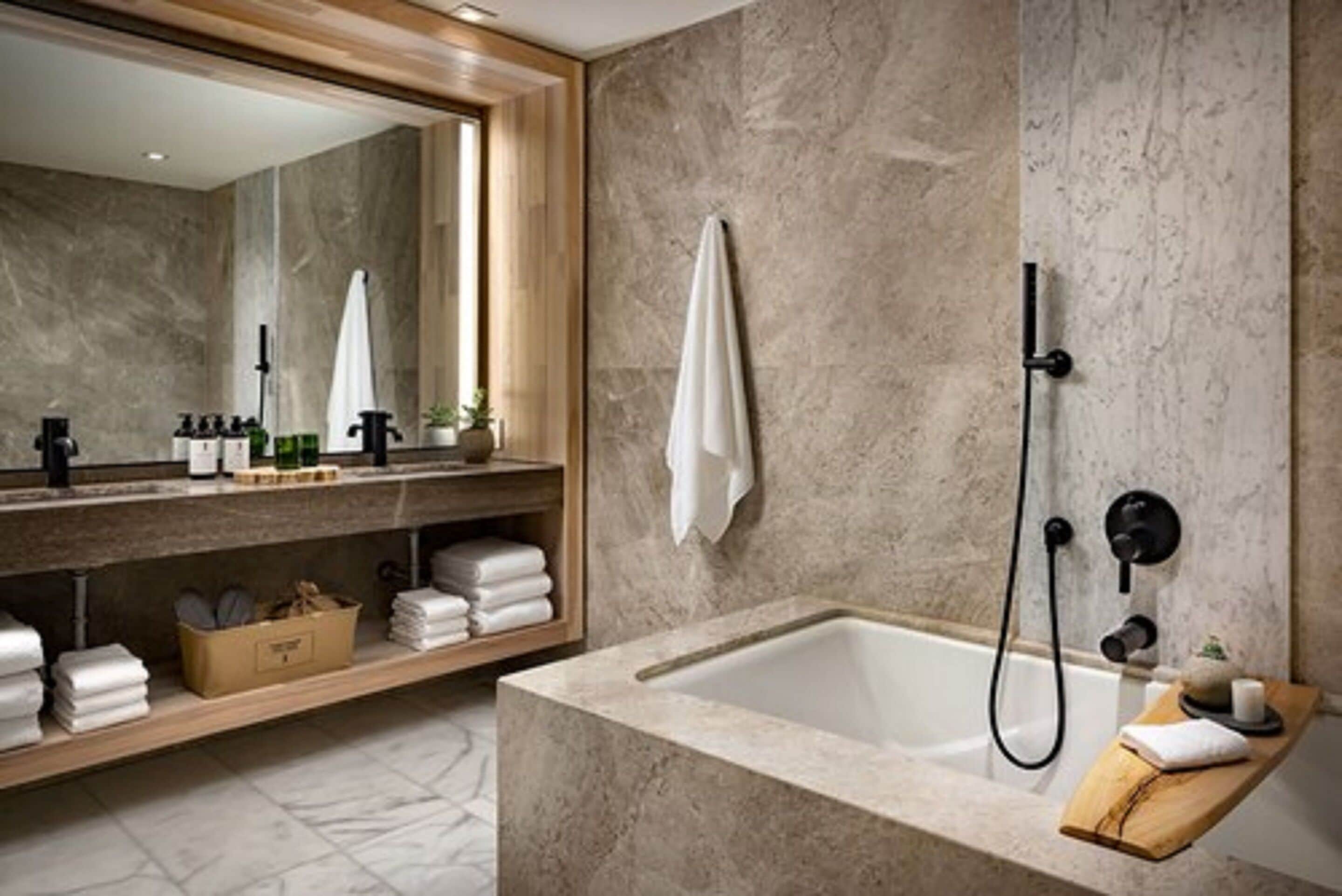 A modern bathroom with a large mirror, a bathtub, and a shower.