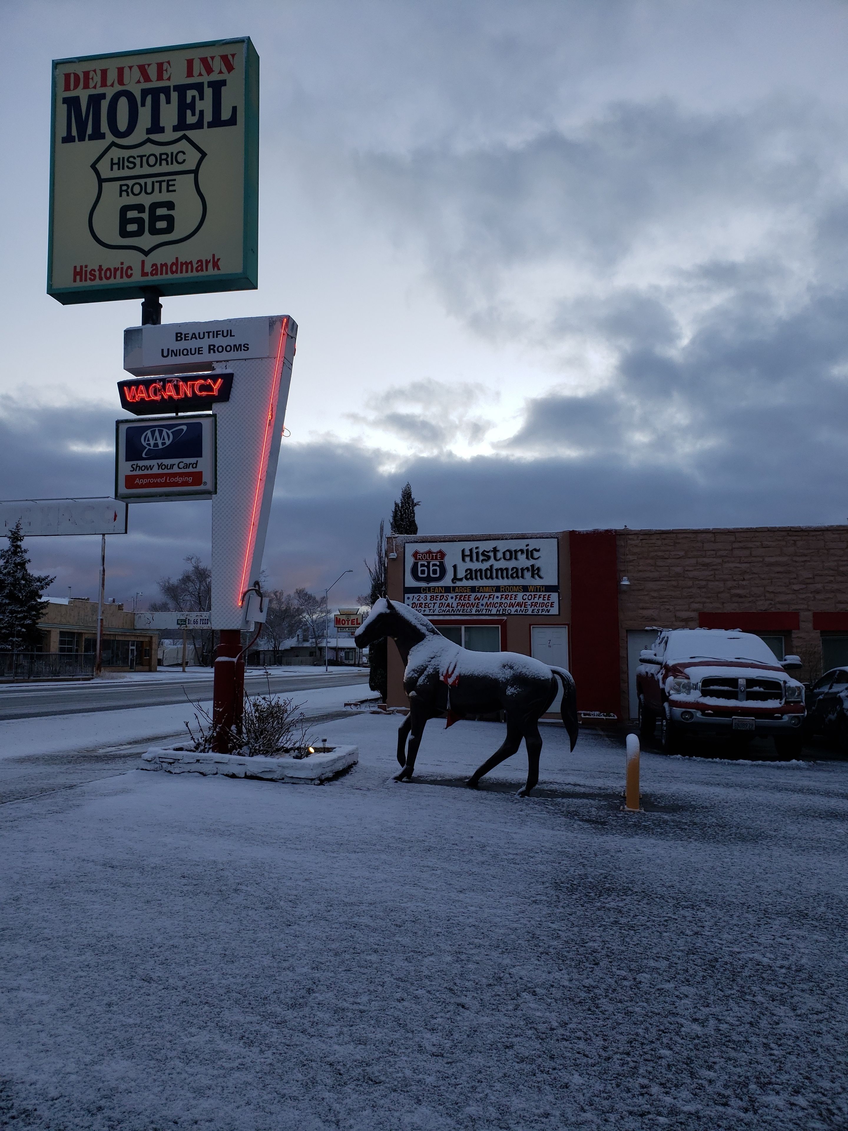 Letrero de motel con una estatua de caballo cubierta de nieve.
