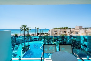 Un resort con piscina, palmeras y vista al océano.