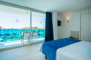 A hotel room with a large sliding glass door leading to a balcony with a pool view. - Hotel THB Sa Coma Platja (Sant Llorenc des Cardassar)