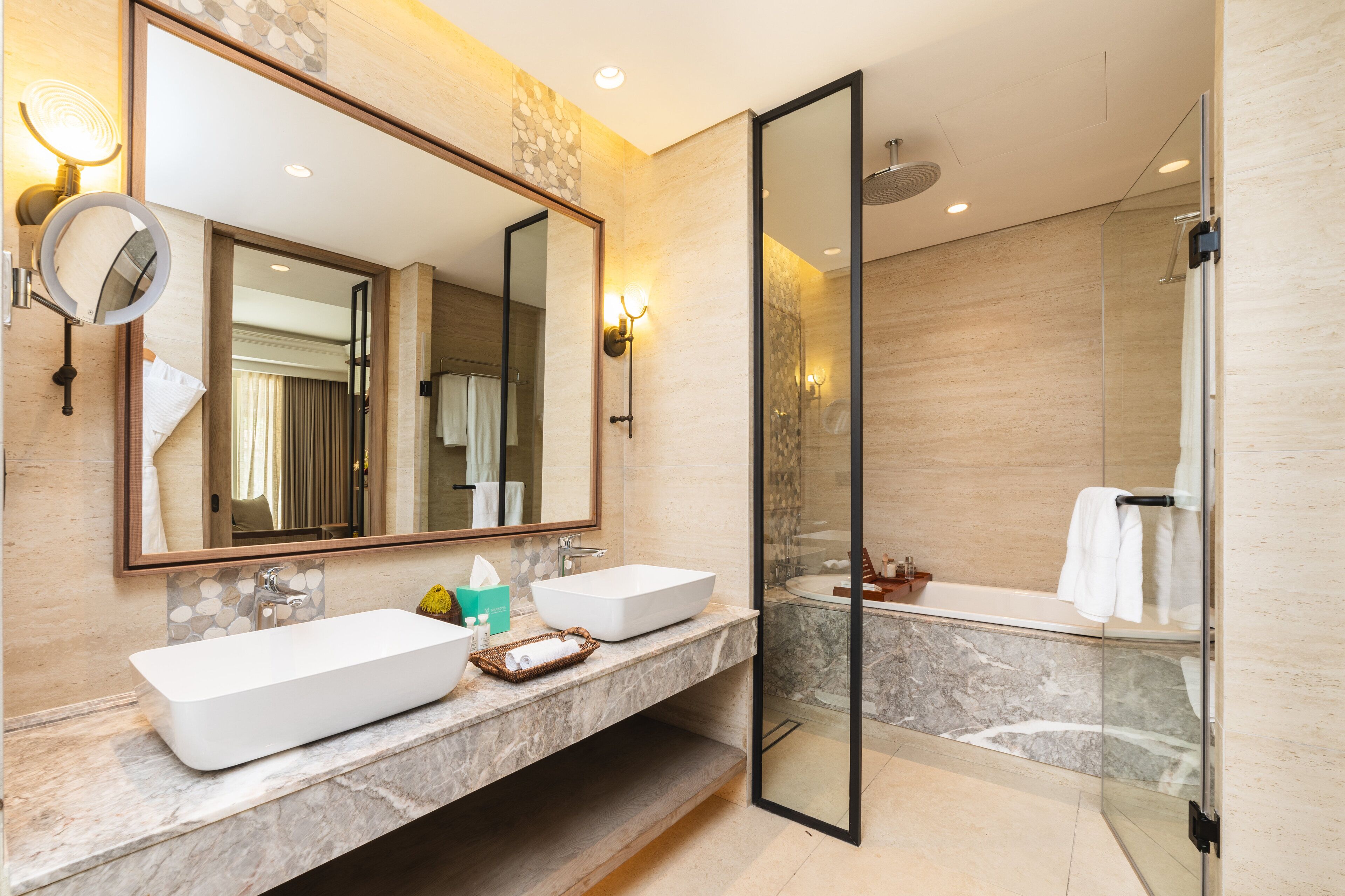 Un bagno moderno con uno specchio grande, due lavabi, una vasca e una cabina doccia in vetro.
