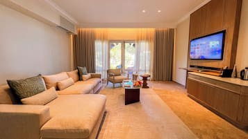 Una sala de estar moderna con un sofá color beige, una mesa de centro y un televisor.