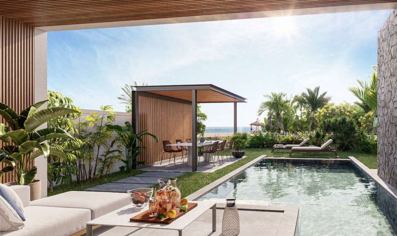 Un área de piscina moderna al aire libre con sillones de descanso, comedor y vista al océano.