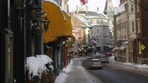 A street view with a sign for 'Hôtel Louisbourg' hanging above a building. - Hotel Louisbourg (Québec City)