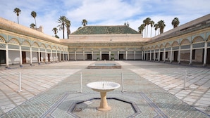 A courtyard with a central fountain, tiled floor, and palm trees. - Riad Limouna (Marrakech)