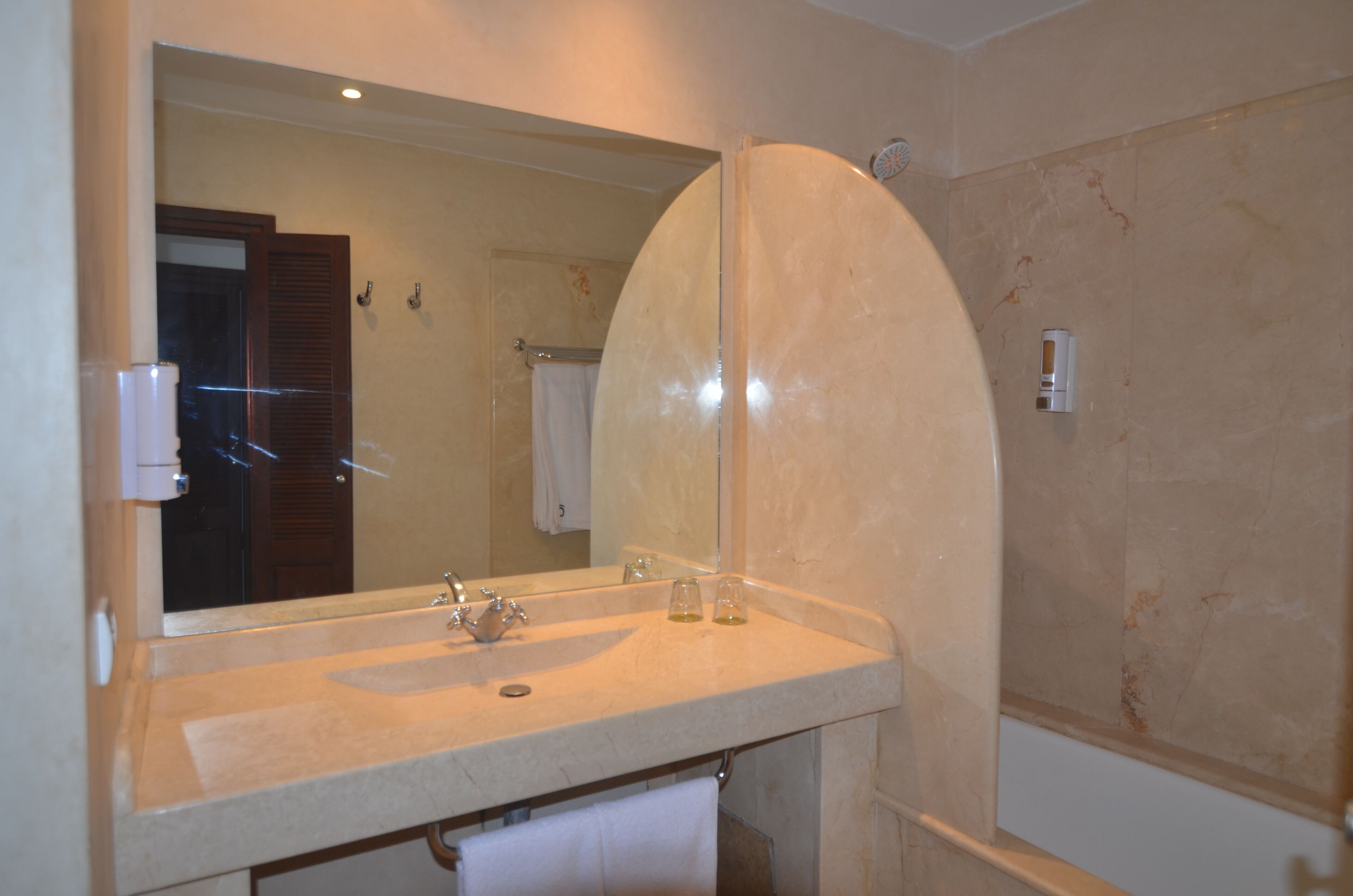 Un bagno con uno specchio grande, un lavandino e un porta asciugamani.
