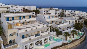 A coastal hotel with white buildings, a swimming pool, and a view of the sea. - Aloni Hotel (Paros)