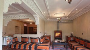 Un salón tradicional con un conjunto de sofás, una chimenea y un techo decorativo.