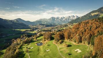 Enjoy a serene golfing experience amidst majestic mountains and lush tree-lined fairways.