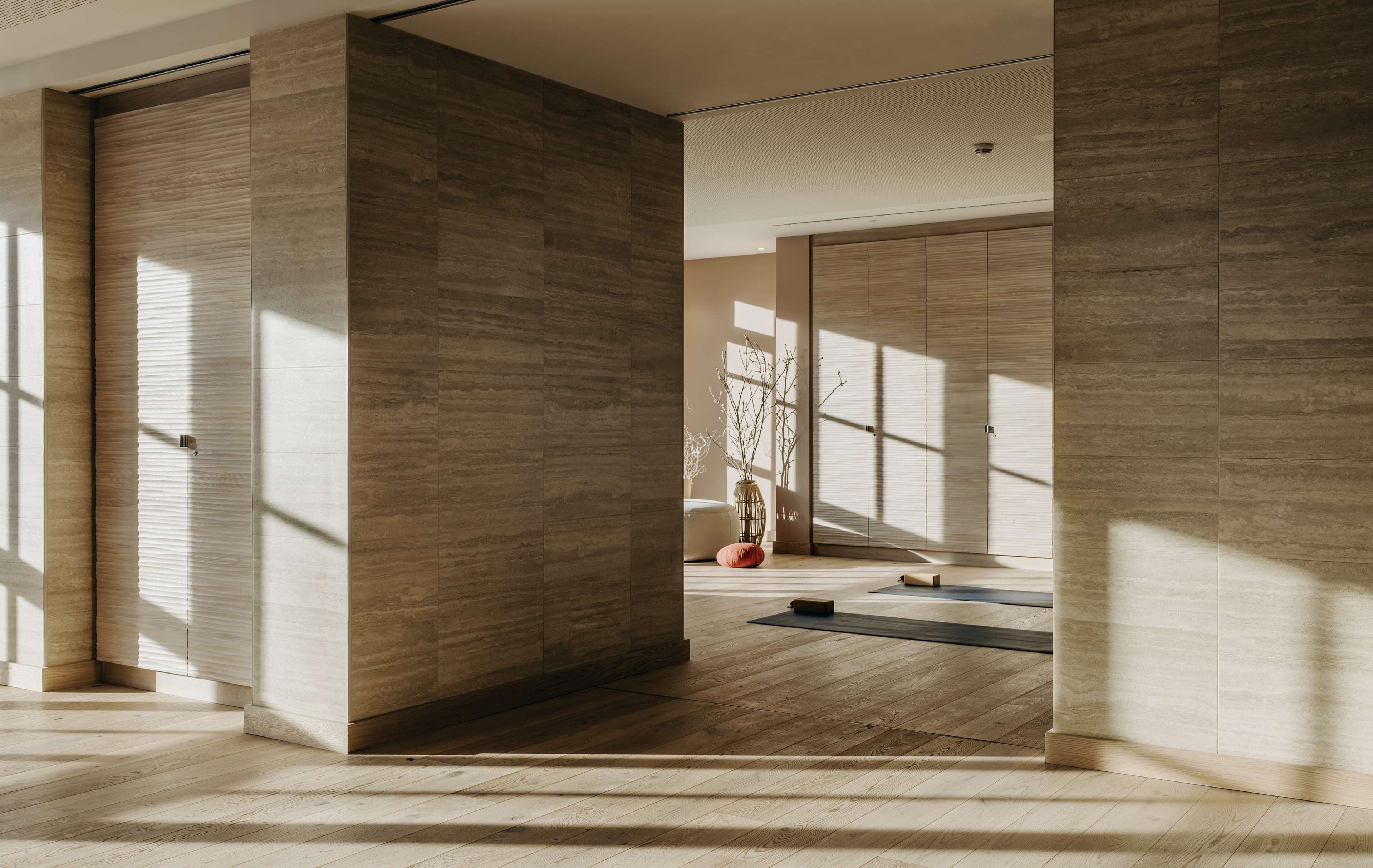 Une pièce spacieuse dotée de grandes fenêtres, d’un plancher en bois et d’un aménagement minimaliste.
