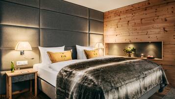 A modern bedroom with a large bed, two bedside tables, and a wooden accent wall.