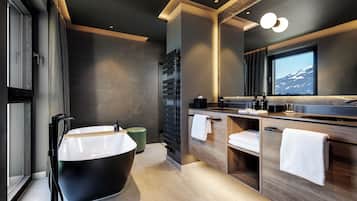 A modern bathroom with a freestanding bathtub, wooden vanity, and a large mirror.
