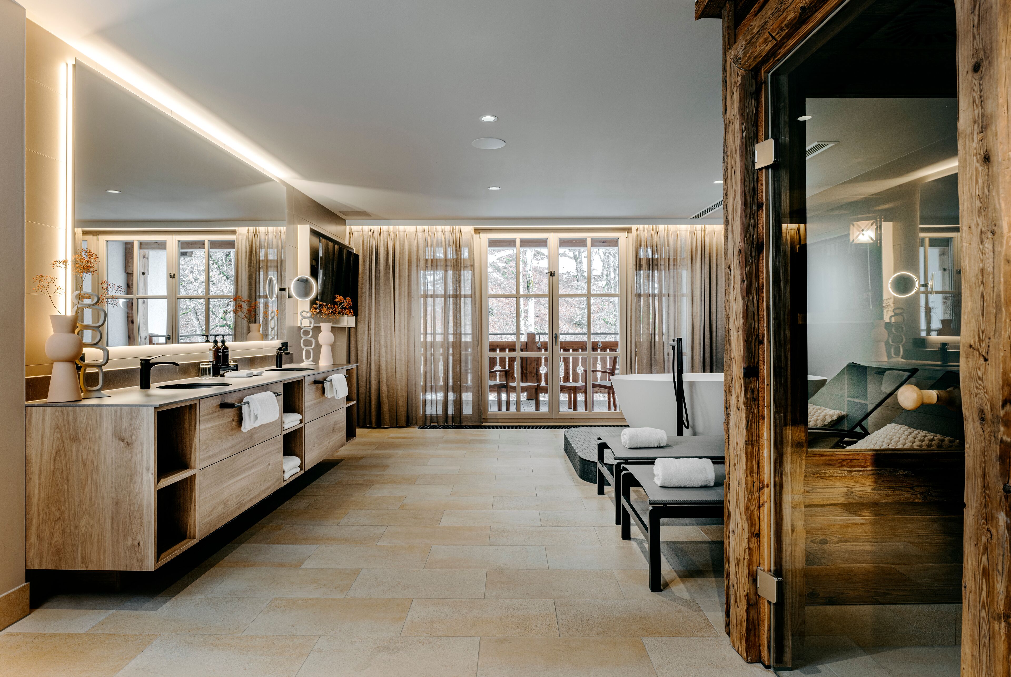 Une salle de bain moderne avec un meuble-lavabo en bois, un grand miroir et une cabine de douche en verre.
