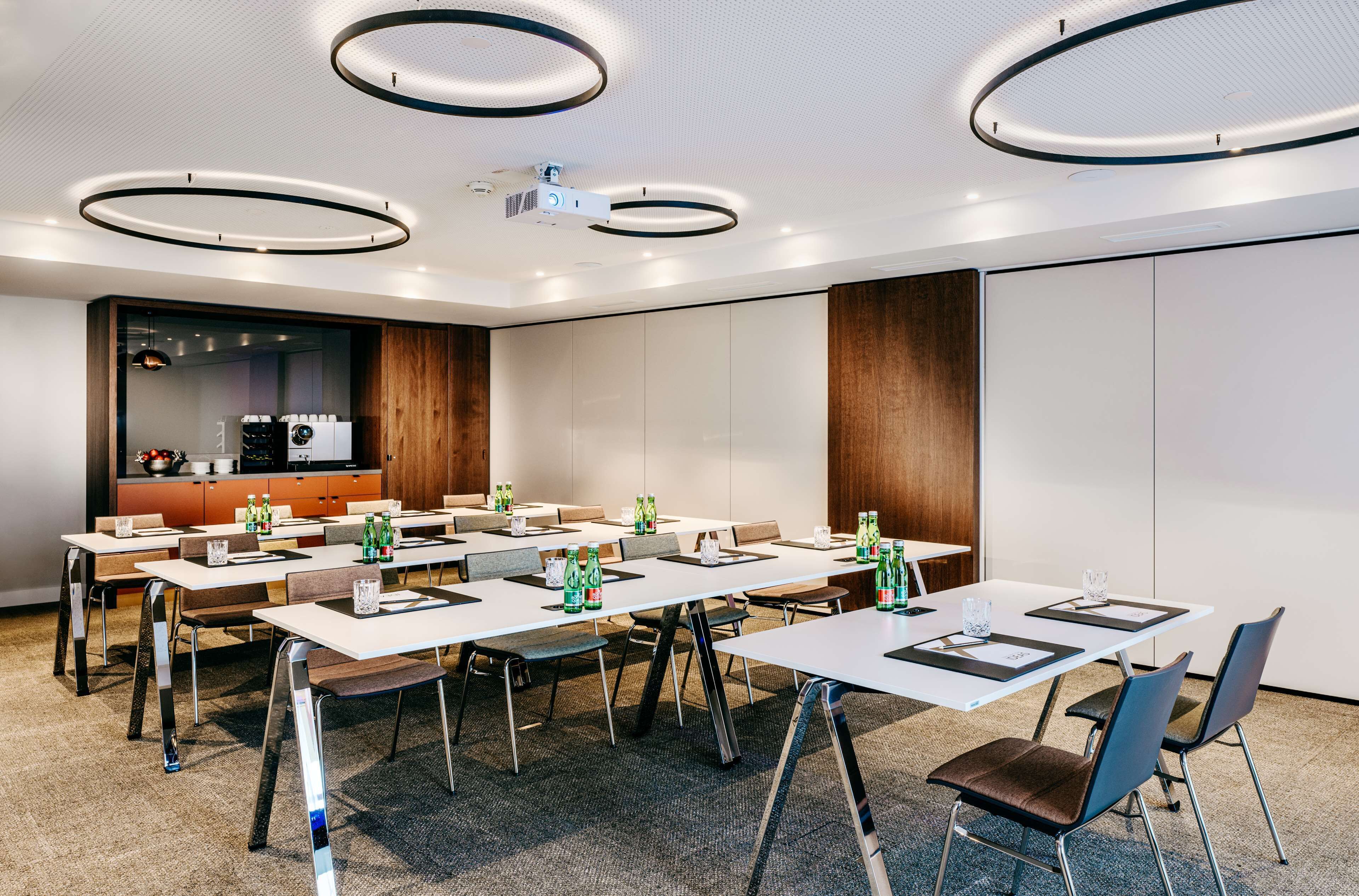 A conference room with multiple tables, chairs, and a projector.