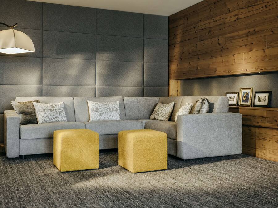 Una sala de estar moderna con un sofá gris, dos otomanas amarillas, una lámpara de pie y un panel de pared de madera.