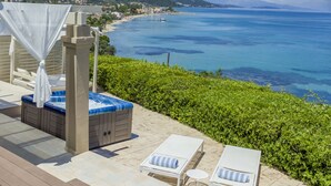 A poolside area with a hot tub, lounge chairs, and a view of the sea. - Palms and Spas Corfu Villas Retreat (Corfu)