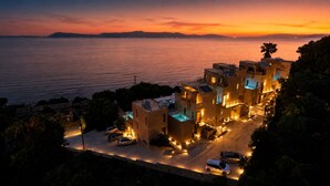 A coastal hotel with multiple buildings, a swimming pool, and a view of the sea. - Palms and Spas Corfu Villas Retreat (Corfu)