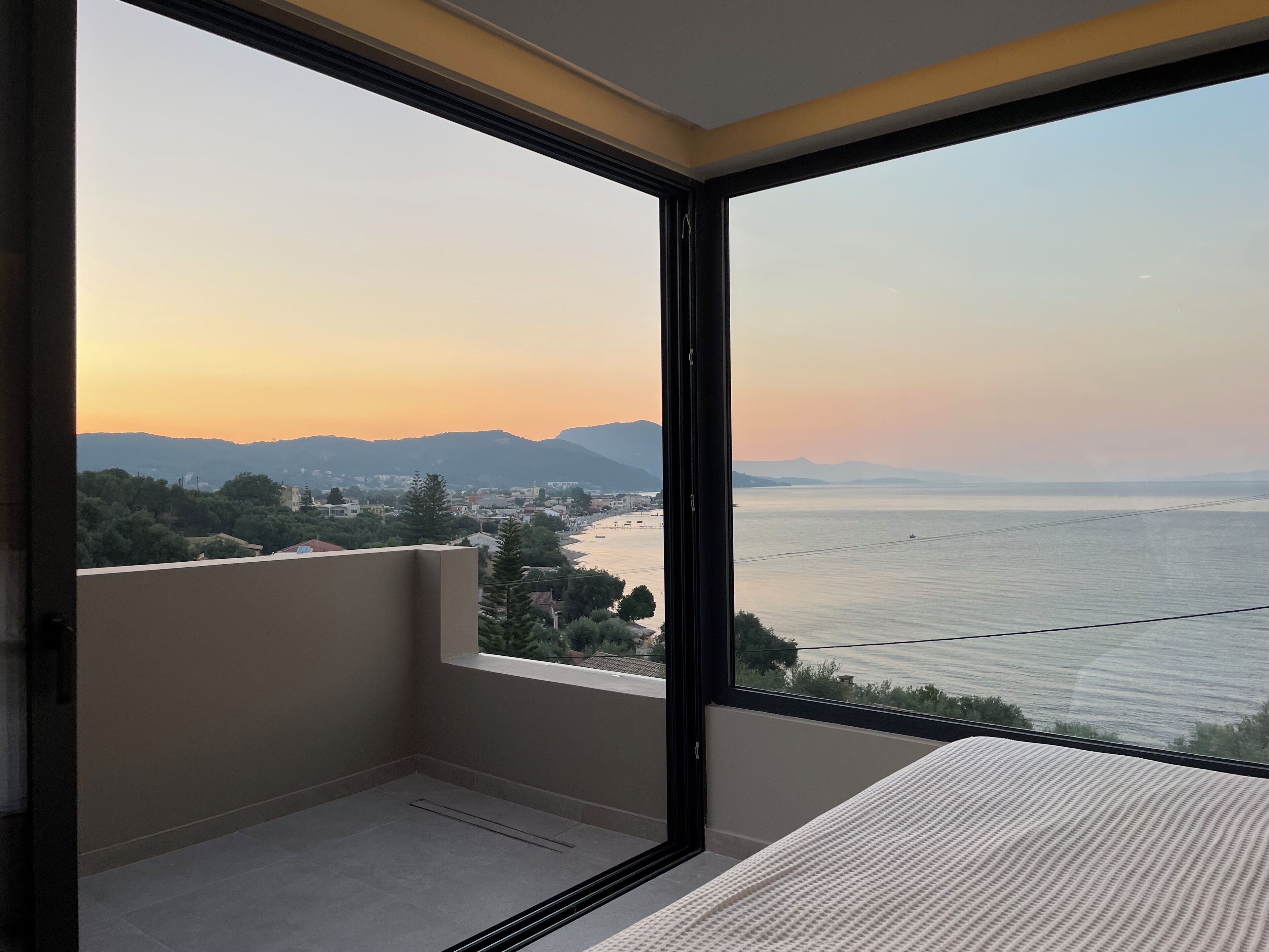 Un balcón con vistas a una ciudad costera durante el atardecer.