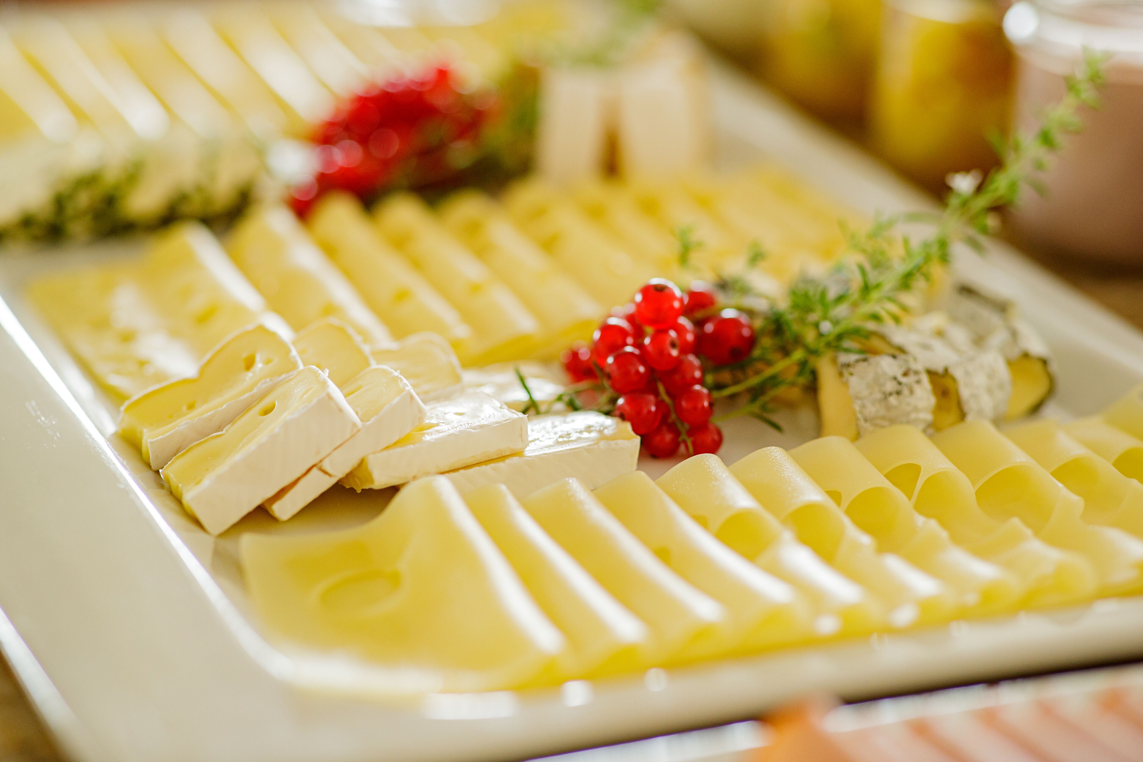 Una tabla de quesos con varios tipos de queso y adornos.