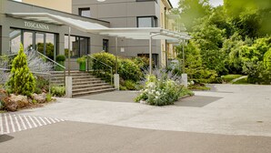 Un hôtel moderne, doté d’une entrée couverte et d’un escalier menant à l’entrée.