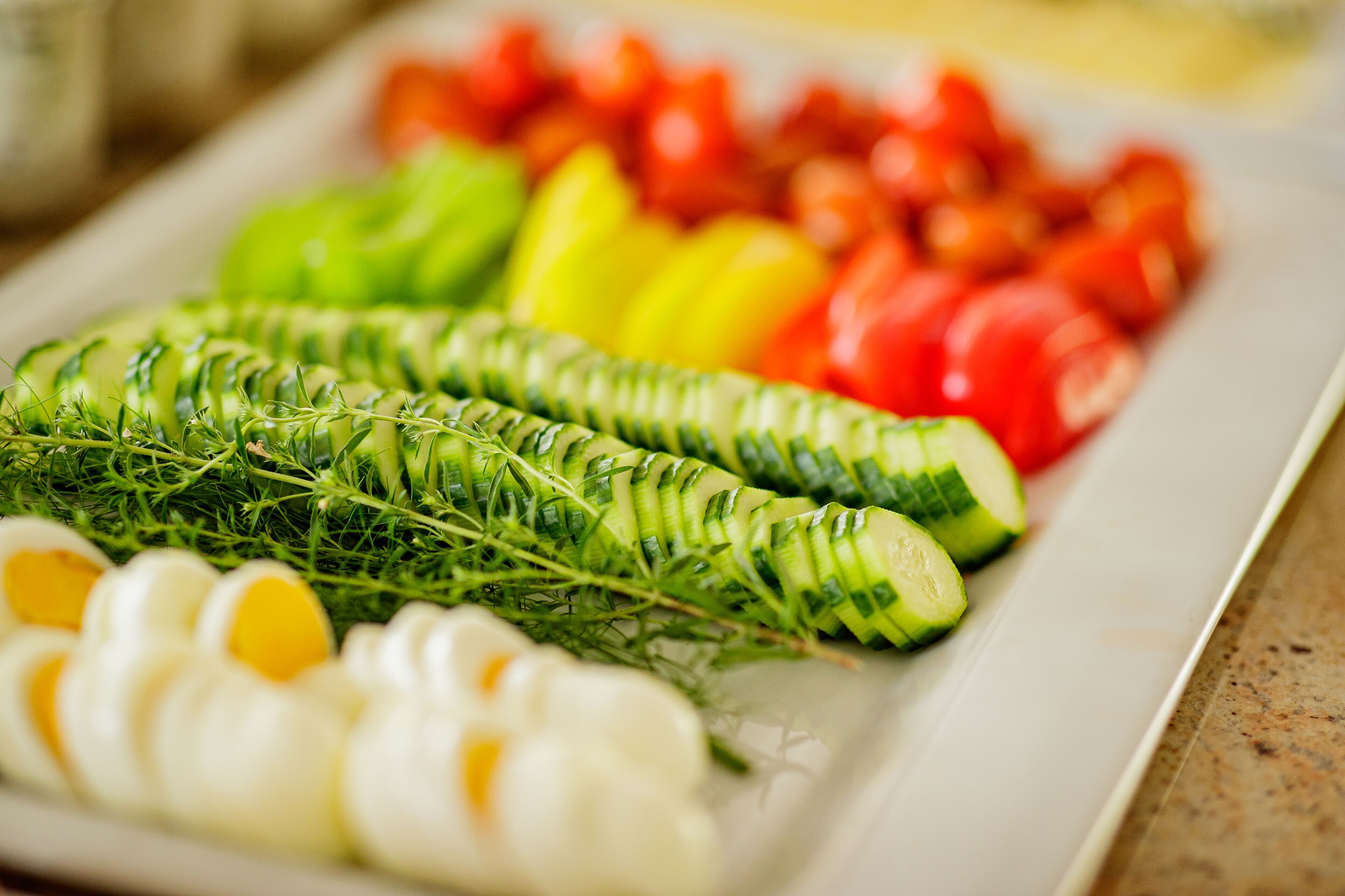 Une assiette contenant des tranches de concombre, des tomates et des œufs.