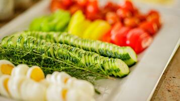Une assiette contenant des tranches de concombre, des tomates et des œufs.
