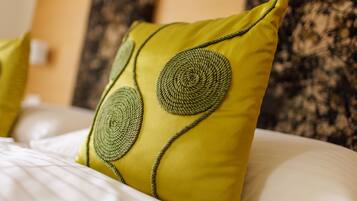 Una cama con un almohadón amarillo y un diseño circular.