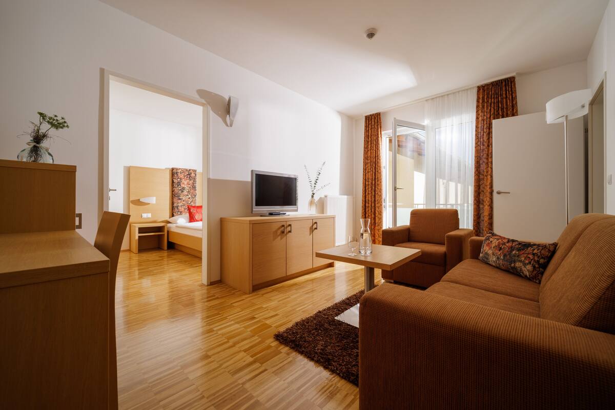 Ein modernes Wohnzimmer mit einer Couch, einem Couchtisch, einem Fernseher und einem Schrank.