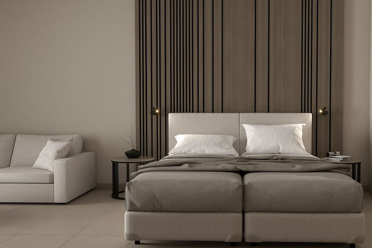 Une chambre moderne avec un grand lit, un canapé et un mur orné de lignes verticales.