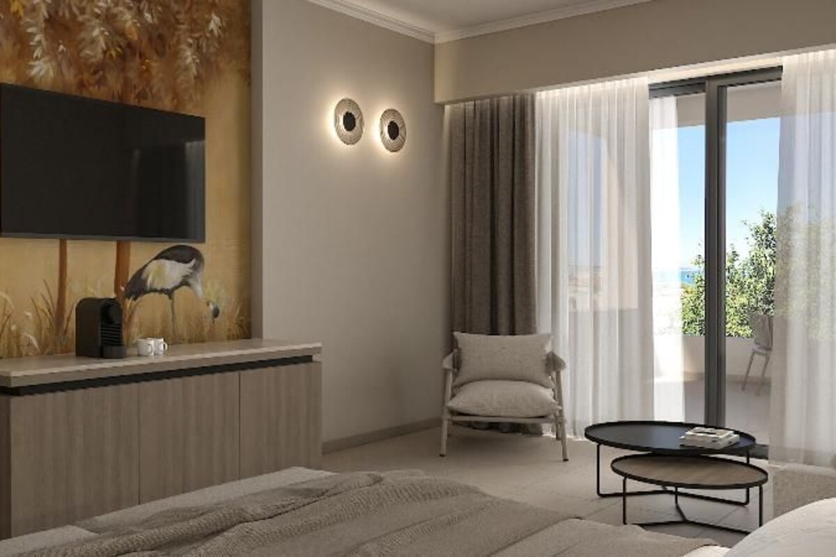 Un dormitorio moderno con cama, mesita de noche, televisor, sillón y balcón con cortinas.