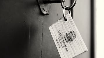 Una cerradura metálica con un llavero y una llave, y una placa de madera con texto.