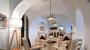A spacious room with arched ceilings, a central seating area with sofas and armchairs, and a floor lamp. - Gattopardo Park Hotel (Lipari)