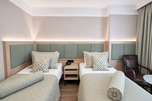 Une chambre d’hôtel avec deux lits, une table de chevet, une chaise et une table.