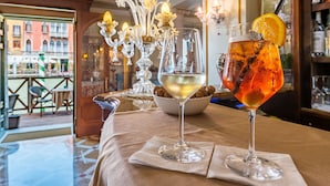 A bar area with two glasses of wine on a table, one with an orange garnish. - Hotel Canal Grande (Venice)