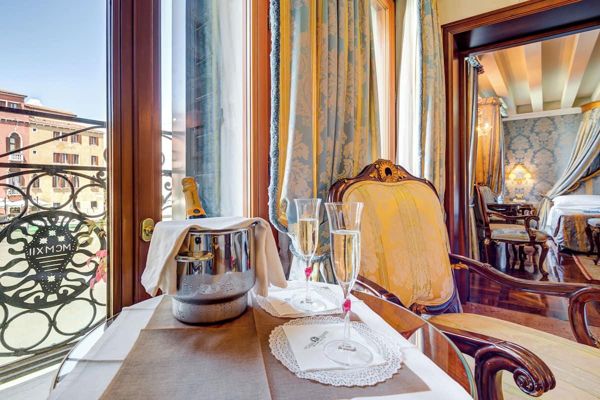 A dining table with a bottle, glasses, and a candle.