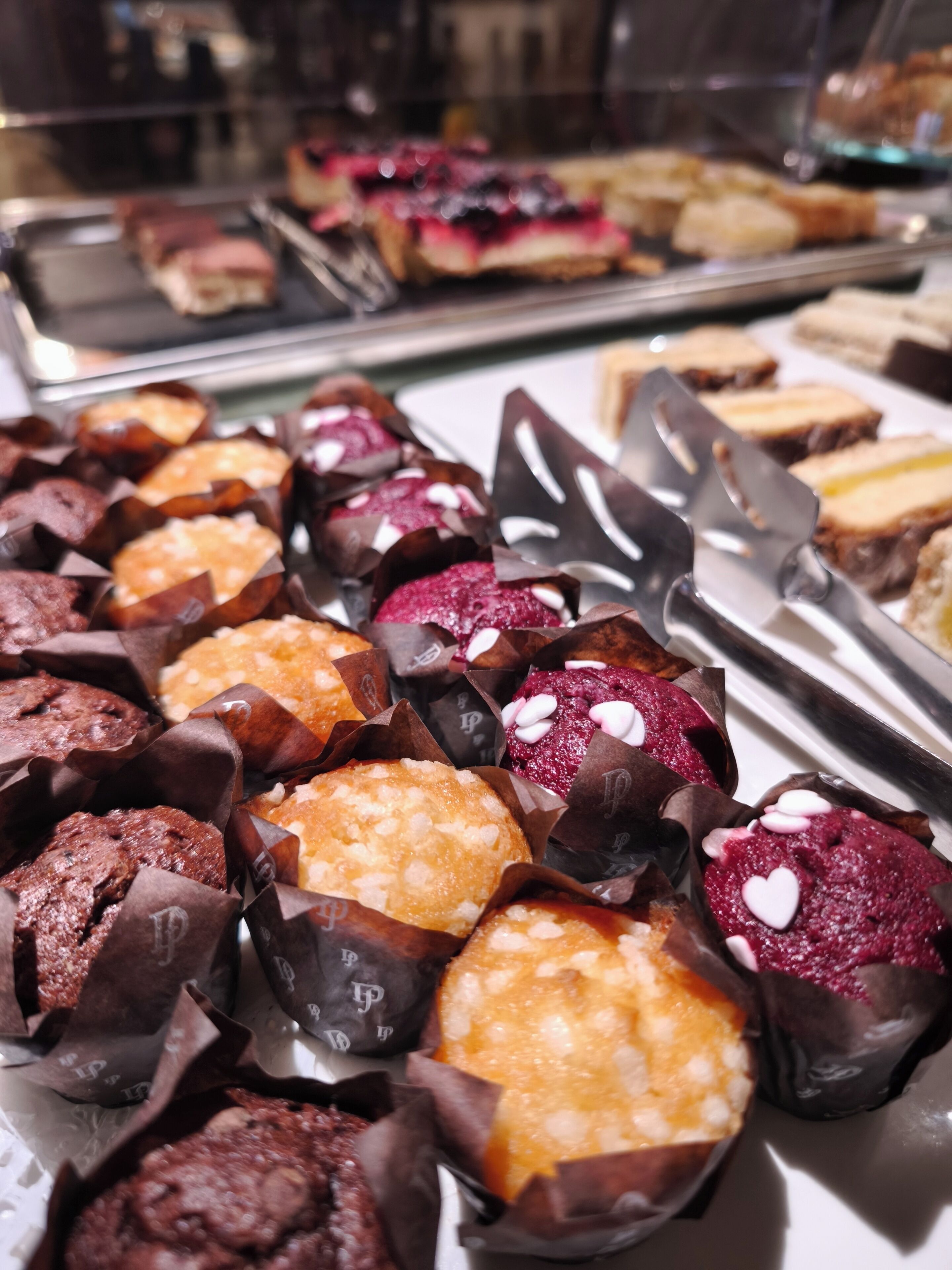 A variety of baked goods displayed in a bakery setting.