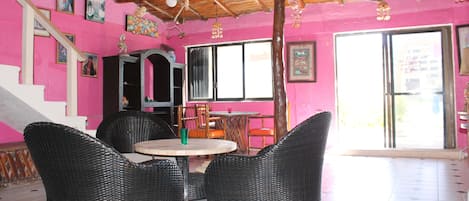 Una habitación con muebles de mimbre, ventilador de techo y una escalera.